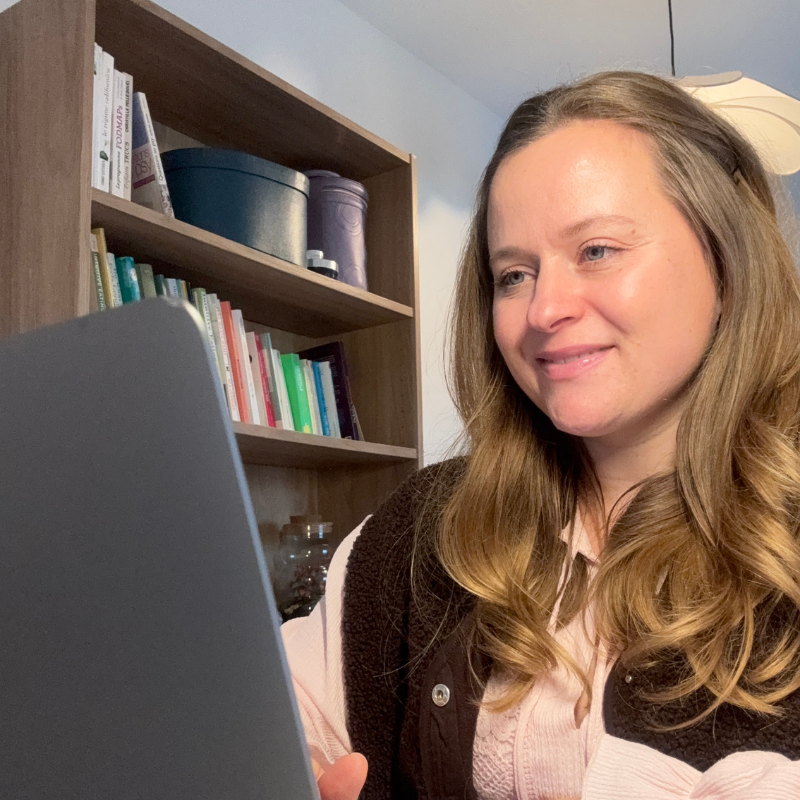 Charlotte Lemaire, coach énergie et hormones, souriante devant son ordinateur